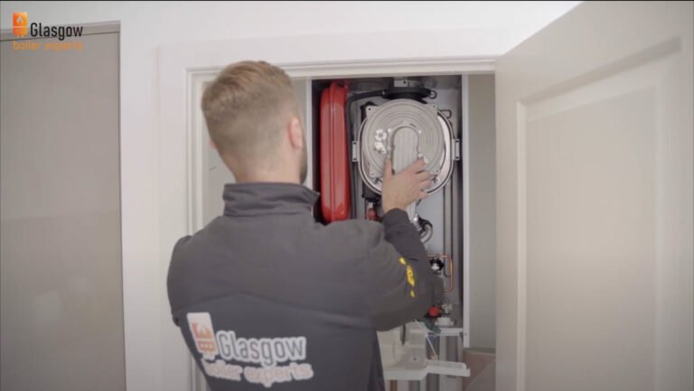Heating engineer is repairing boiler in Glasgow home