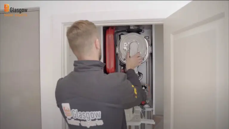 Heating engineer is repairing boiler in Glasgow home